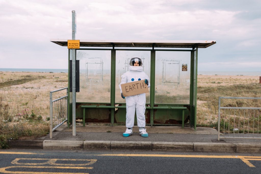 astronaut waiting at a bus stop